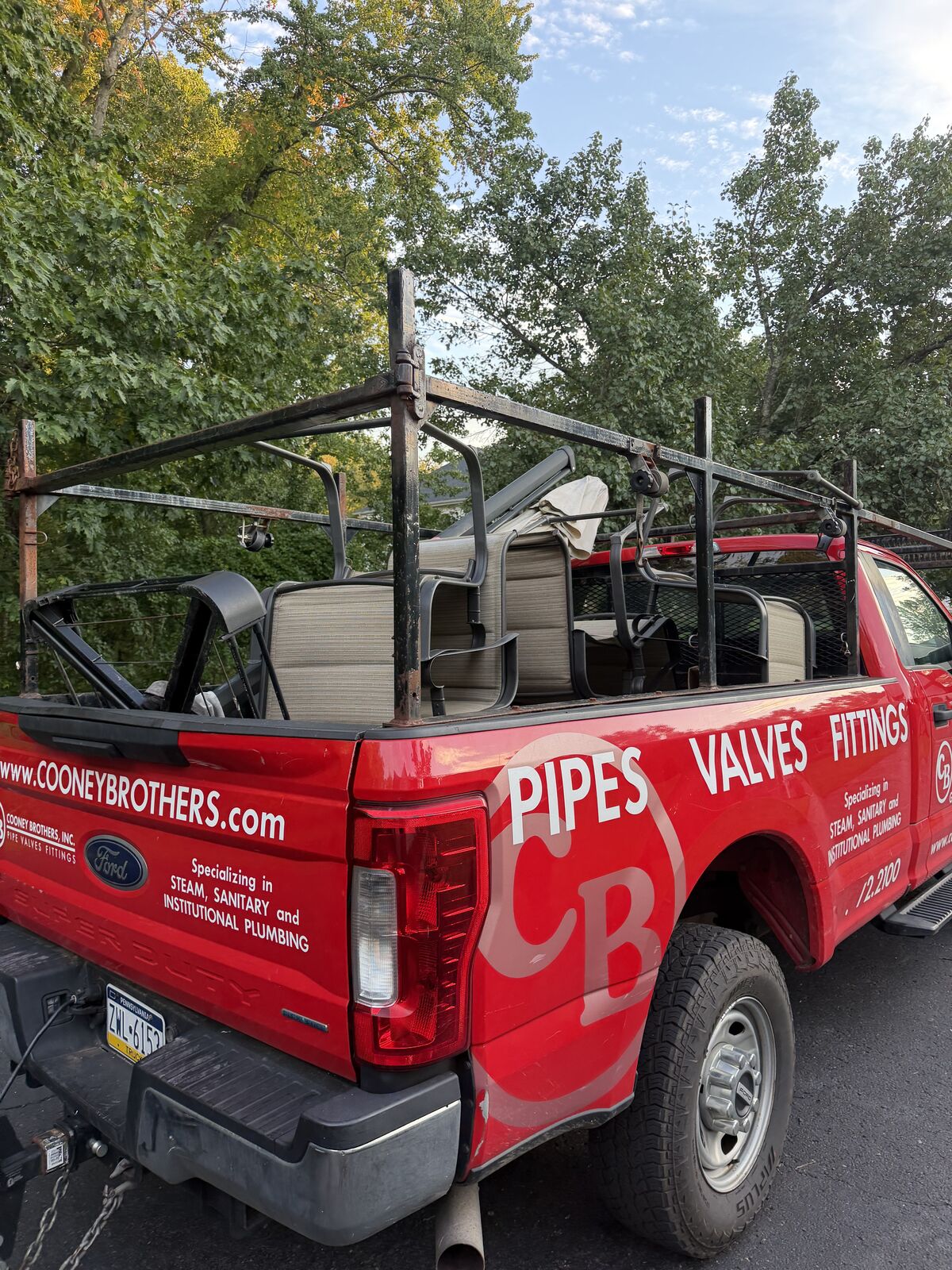 Red pickup loaded with patio chairs and outdoor furniture